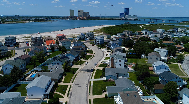 Photo of Brigantine beach with houses in foreground and Atlantic City skyline in background